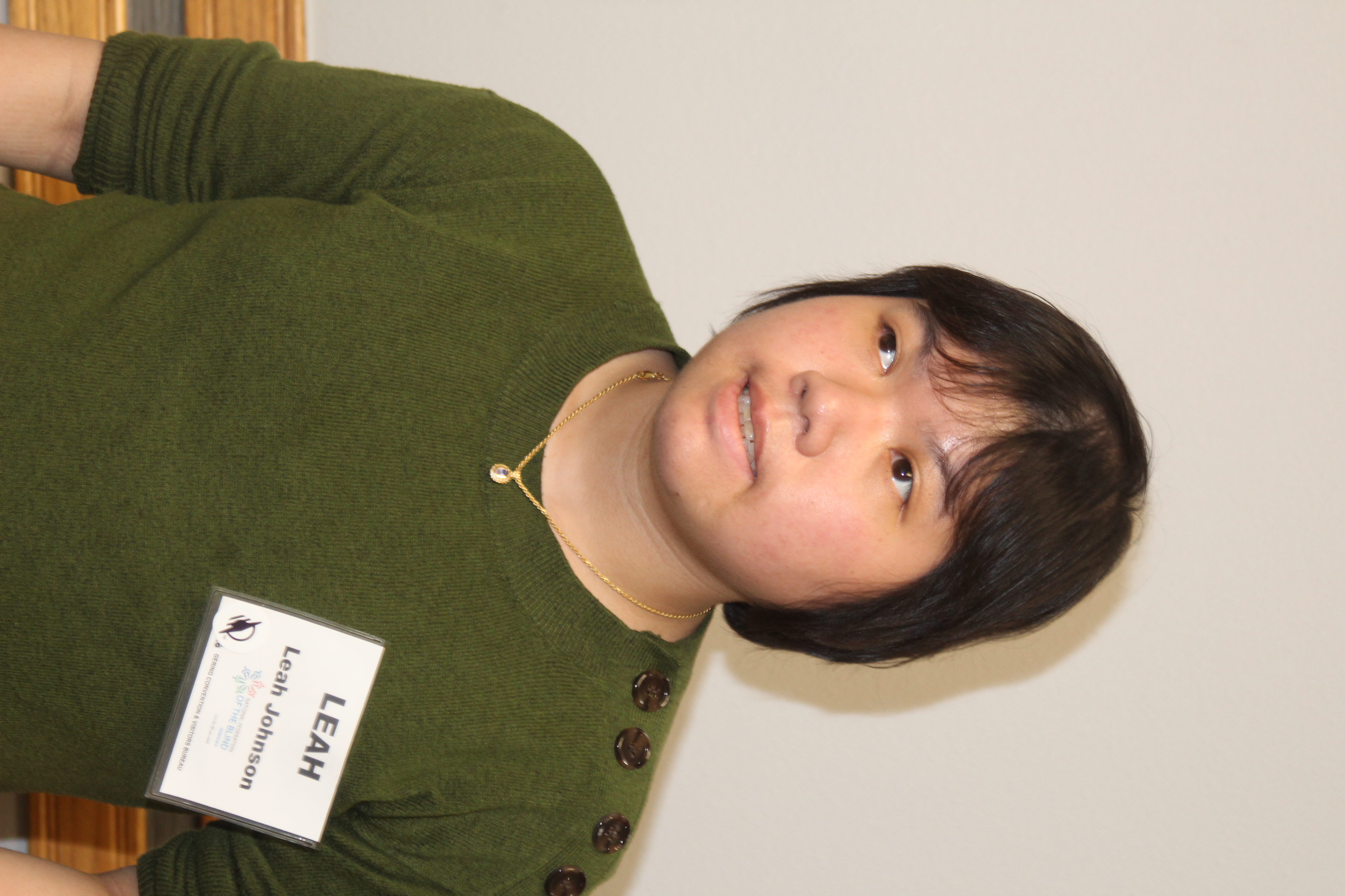 Leah Johnson wearing a green sweater and a necklace.
