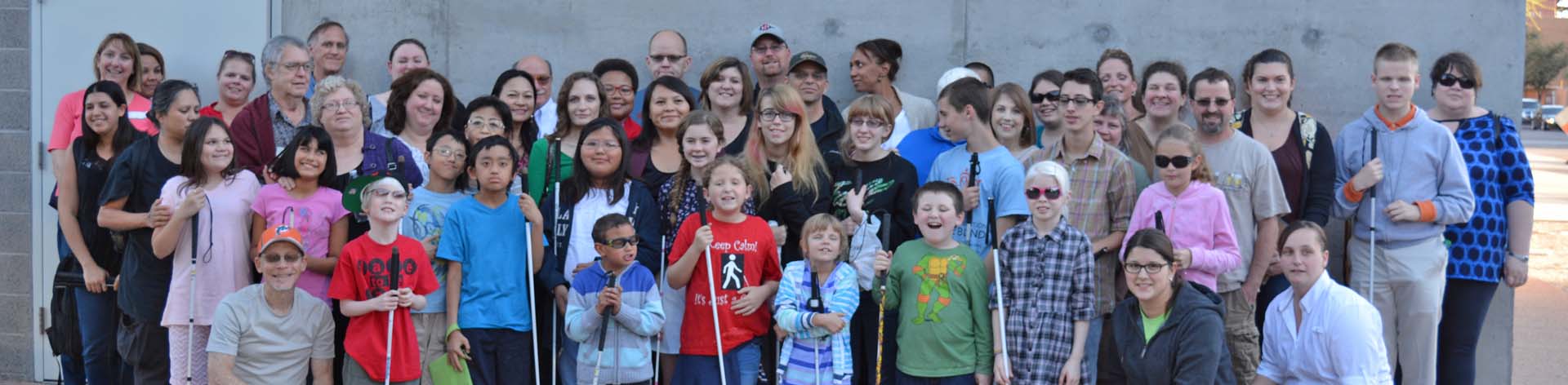 A large group of blind kids, mentors and their parents pose together for a group photograph during am NFB STEM2U program.