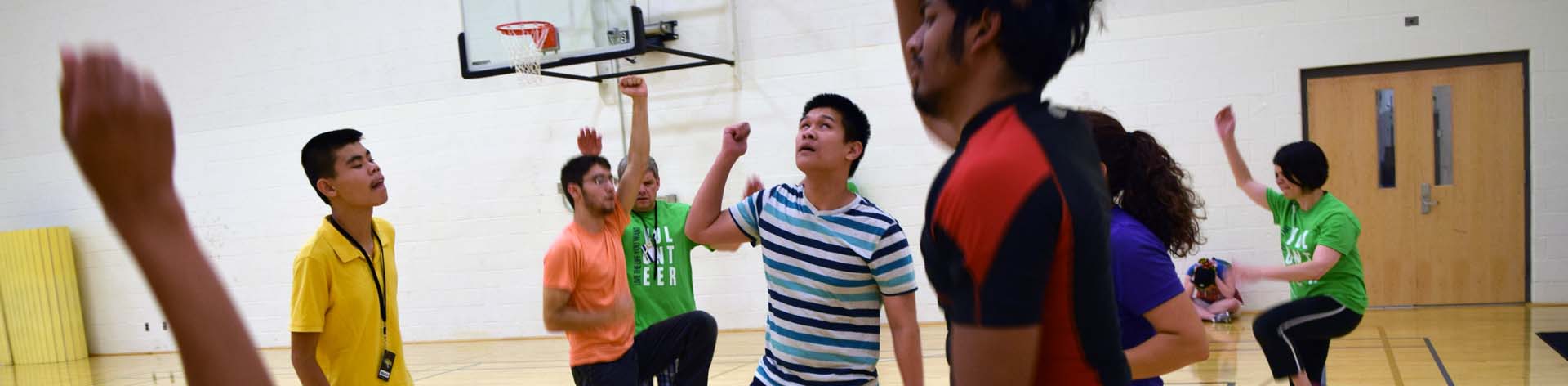 A group of blind teenagers jump around together in a gymnasium